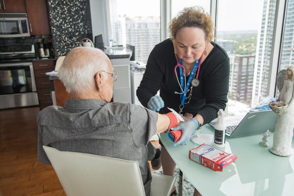 Nurse attending to an elderly patient in a bright room