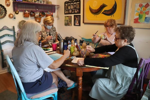 Residents engaged in a painting activity at a table