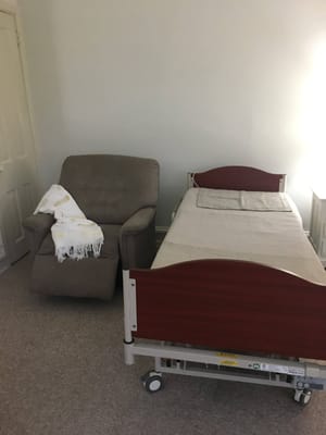 Interior of a resident room with bed and chair