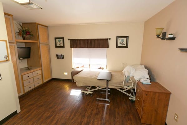 Private room in a senior care facility with hospital bed
