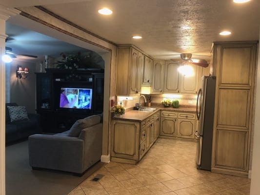 View of kitchen with dining space and living room in background