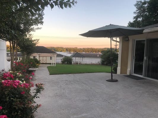 View of the outdoor patio with umbrella and landscaped flowers