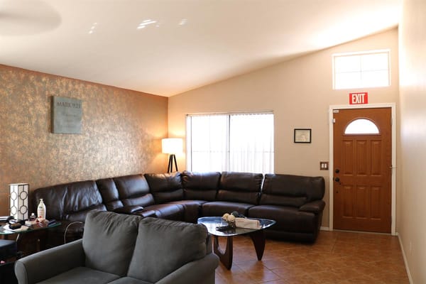 Spacious living room with leather seating and a decorative wall