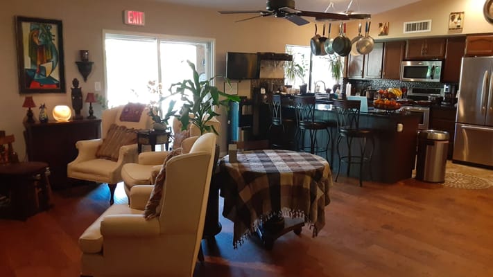 Cozy living room with seating and kitchen in background