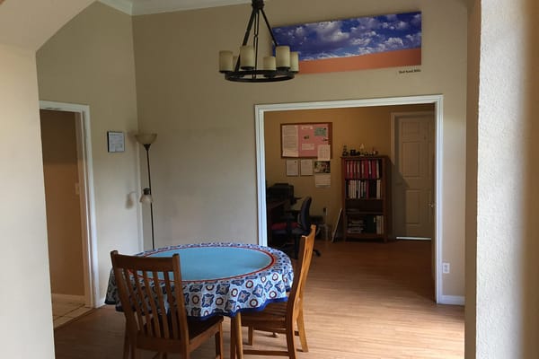 Cozy dining area with a round table and a bulletin board in the background