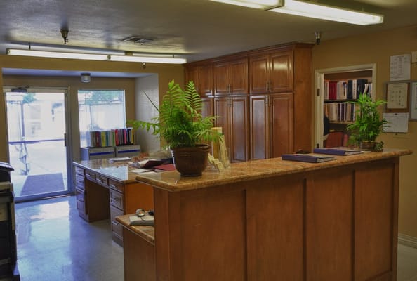 Reception area with wooden cabinets and plants