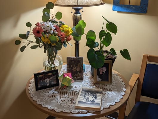 Decorative table with flowers and framed photos