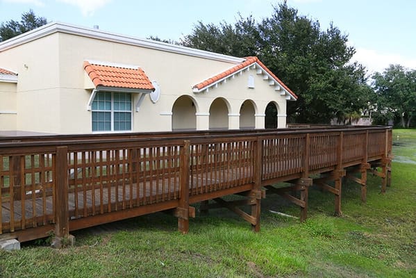 Exterior view of assisted living facility with wooden ramp