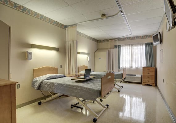 A shared resident room with two beds and a window