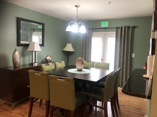 Dining area with green chairs and a large table