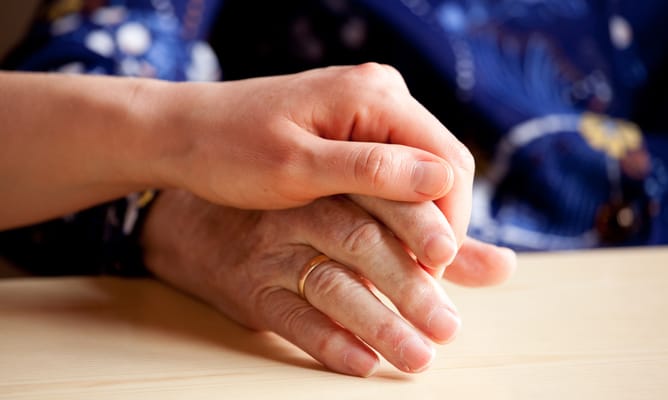 Two hands clasped together, symbolizing support and companionship.