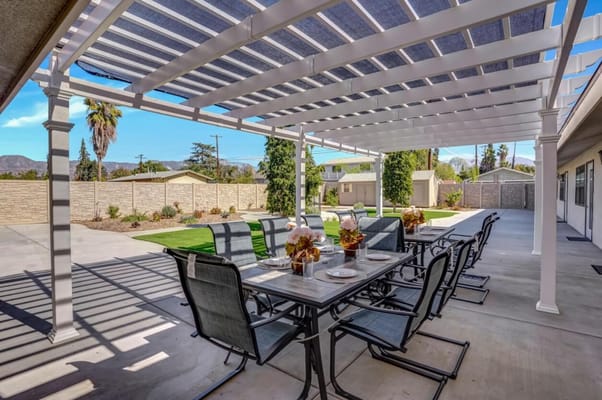 Outdoor dining area with table and chairs under pergola