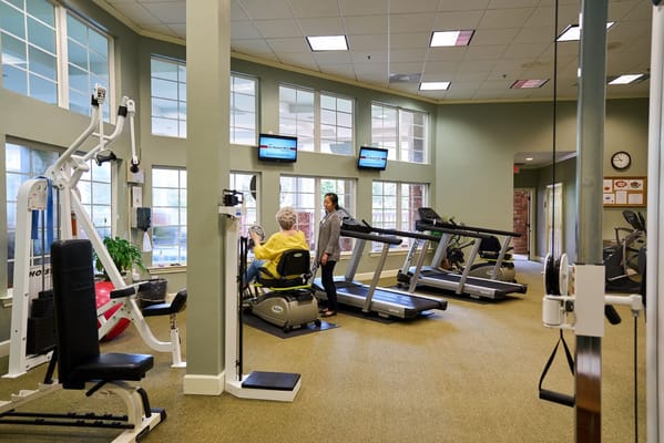 Residents using gym equipment in a fitness area
