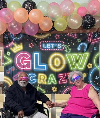 Two residents participating in a glow party activity