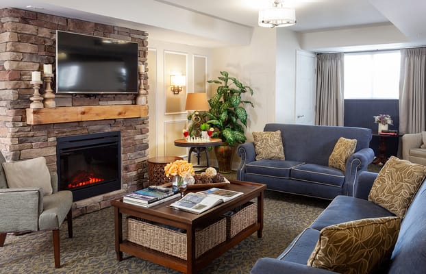 Cozy living room with a fireplace and comfortable seating at Pinebrook senior living facility.