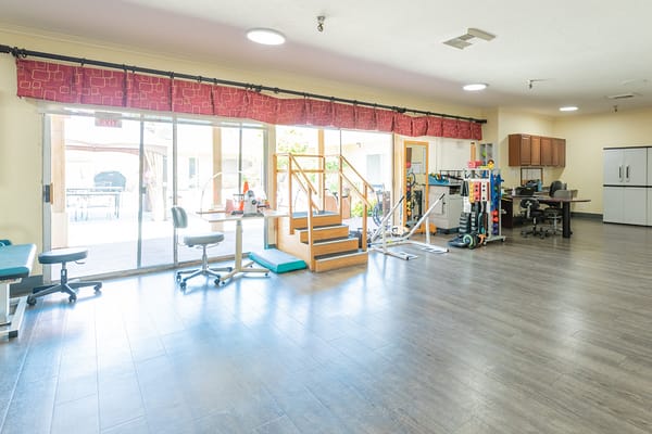 Bright and spacious therapy room with exercise equipment and accessible features.