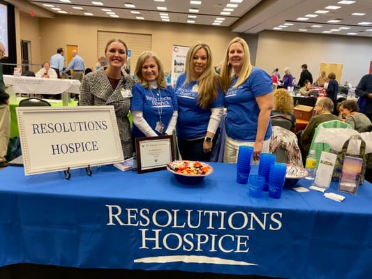 Team members at the Resolutions Hospice booth during an event.