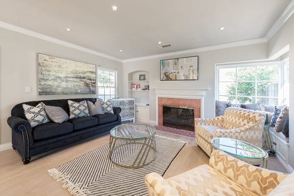 Spacious living room with black sofa and patterned chairs