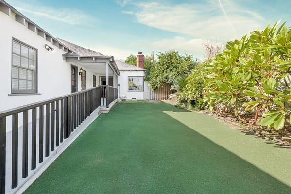 View of a green courtyard with a covered walkway and landscaping