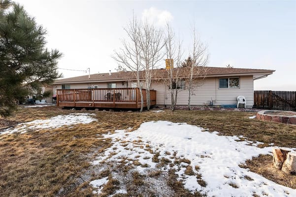 Outdoor space with wooden deck and snow-covered grass