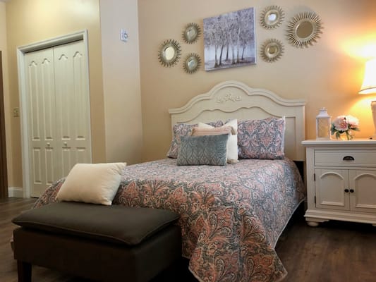 Decorated resident room with a bed and artwork.
