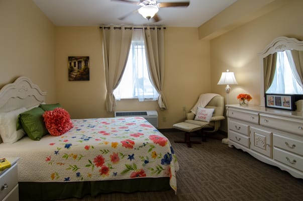 A cozy private resident room with floral bedding