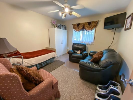 Cozy resident room featuring comfortable seating and personal touches.