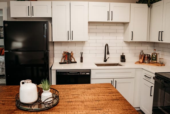 Contemporary kitchen with black appliances and white cabinets