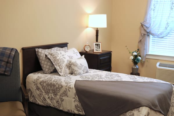 A well-decorated bedroom with a bed, nightstand, and lamp.