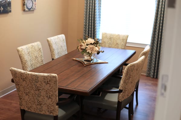 Cozy dining room with a wooden table and floral chairs