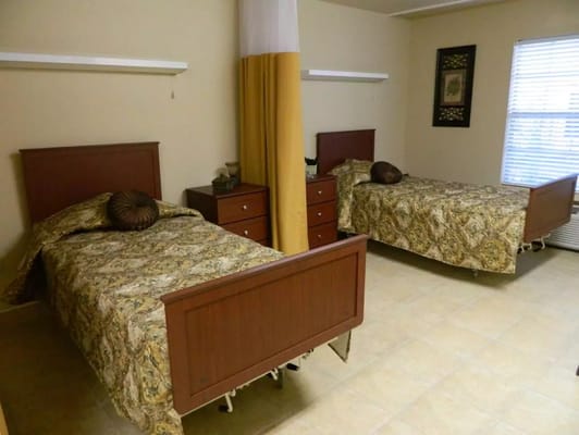 Two beds with patterned bedding in a shared room