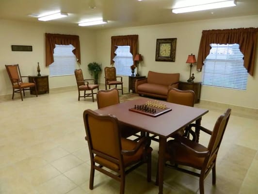 Interior view of a cozy activity room featuring a chess table and seating.