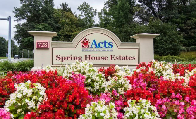 Sign for Spring House Estates surrounded by colorful flowers