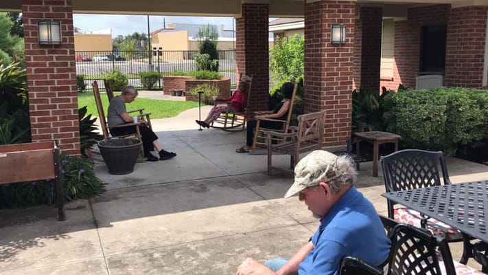Residents enjoying the shaded outdoor seating area