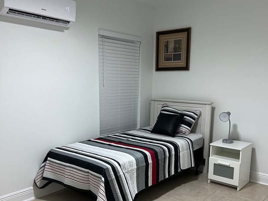 Cozy bedroom with a single bed, bedside table, and framed artwork