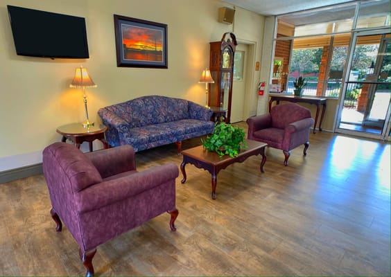 A well-furnished lobby with a floral couch and armchairs.