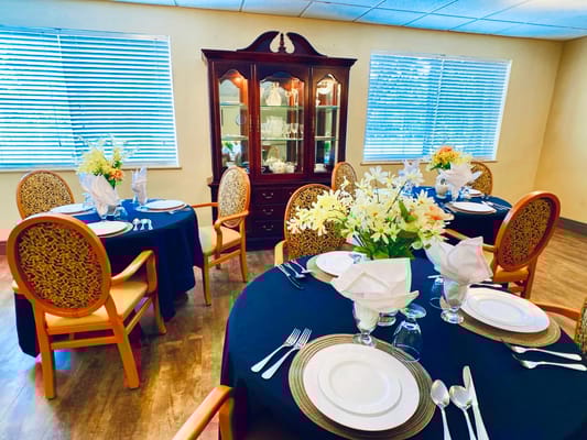Dining room with elegantly set tables and floral arrangements