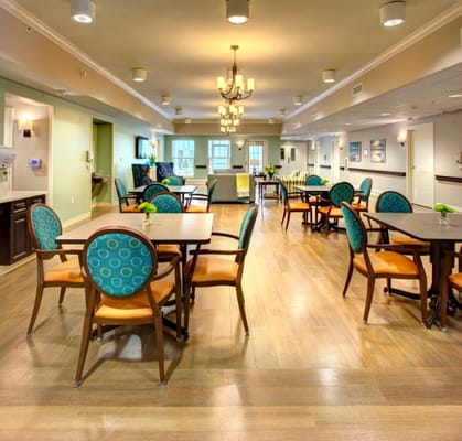 Bright dining area with wooden tables and orange chairs