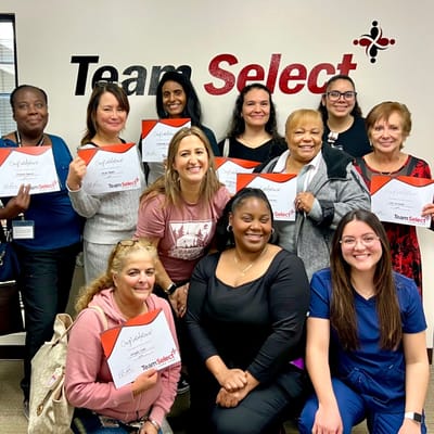 Staff members holding certificates in an office setting