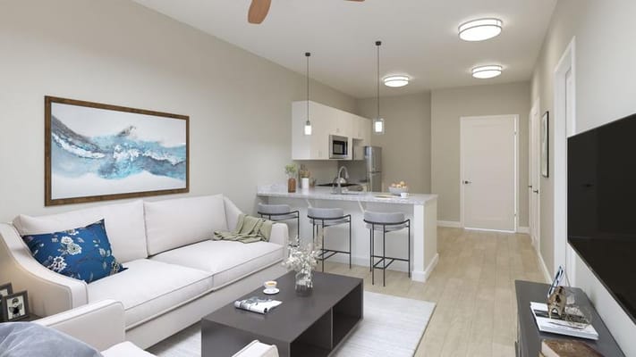 Modern living room and kitchen area with a sofa and dining bar.