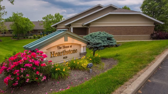 Sign for The Home At Hearthstone surrounded by flowers
