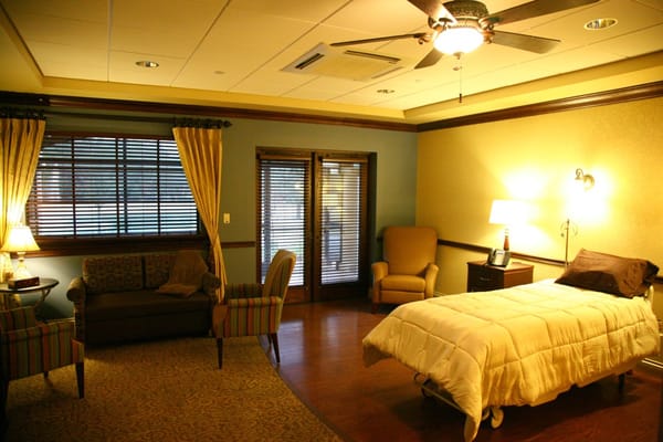 Comfortable patient room with a bed, armchairs, and a sofa