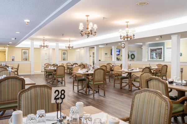 Dining room with tables and chairs set for residents