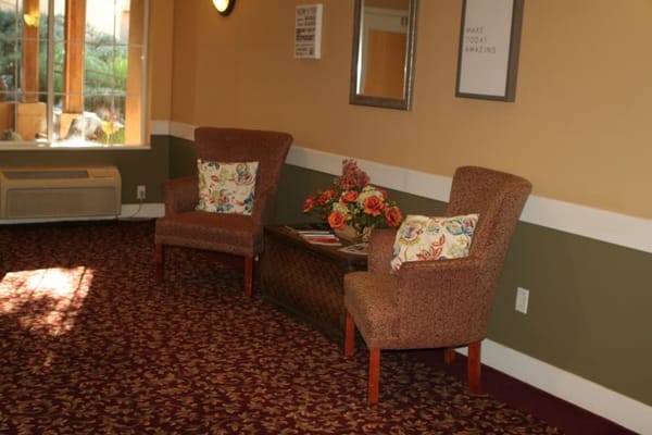 Cozy sitting area with floral pillows and a table.