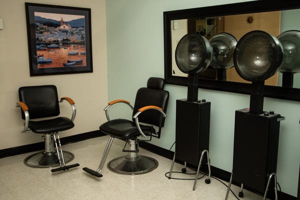 Hair salon area with styling chairs and hair dryers