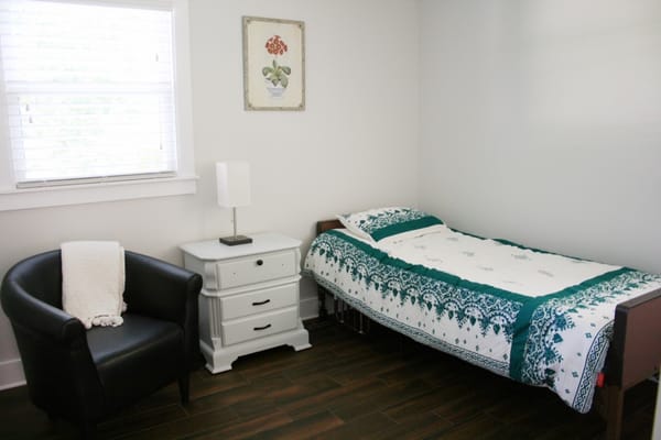 A private resident room with a bed and chair