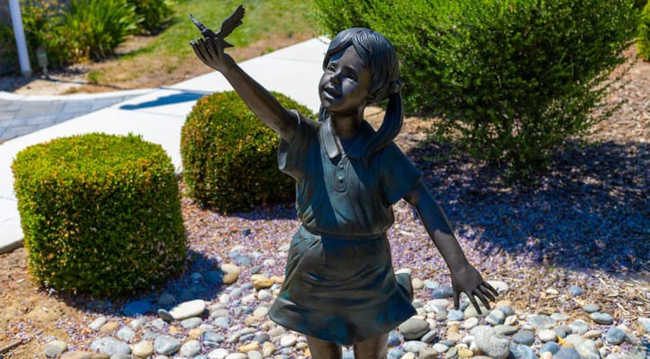 Sculpture of a girl with a butterfly in an outdoor space