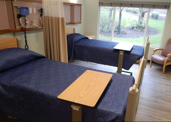 A shared room with two beds and a window view