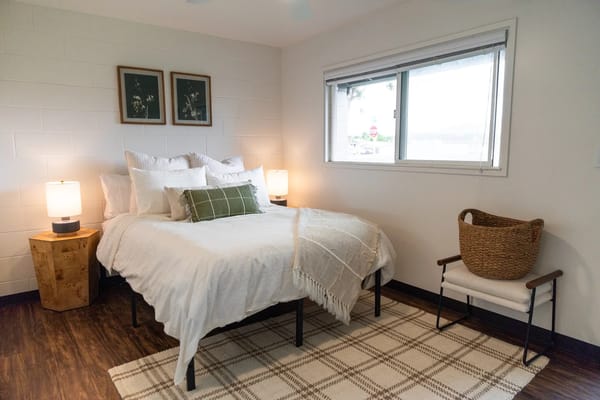 Brightly lit bedroom with minimal decor and a cozy ambiance