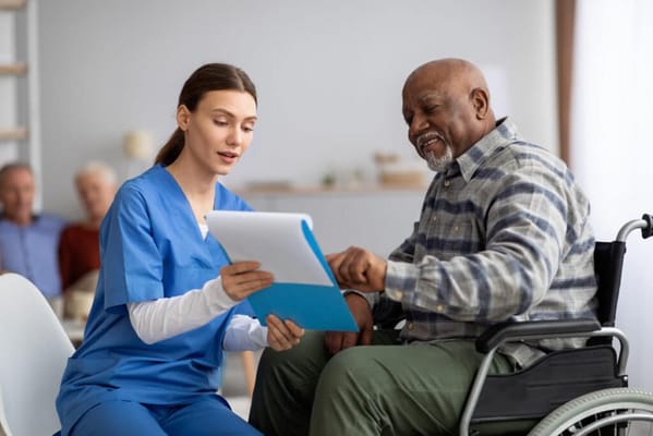 Nurse discussing with a male resident in a wheelchair